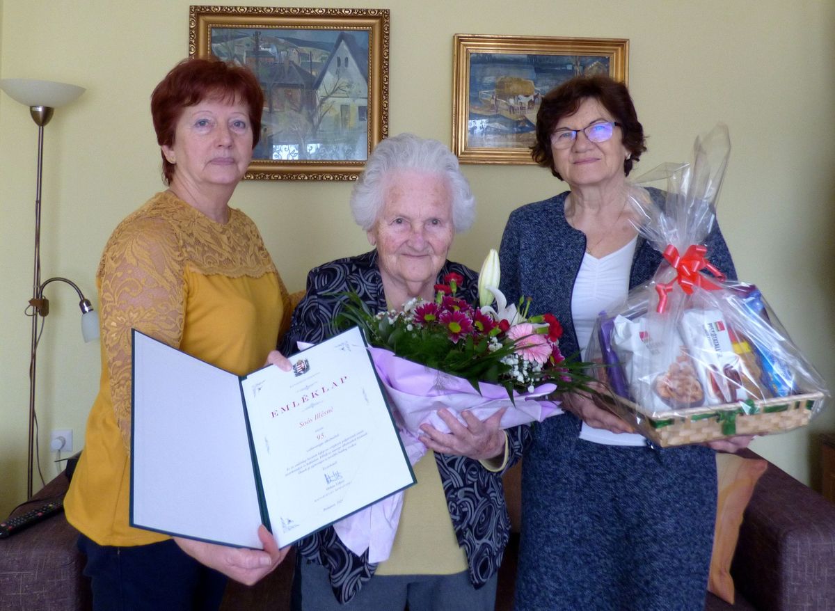 Juhászné Czakó Ilona (balra) és Kiss Lajosné köszöntik a középen álló ünnepeltet, Soós Illésnét