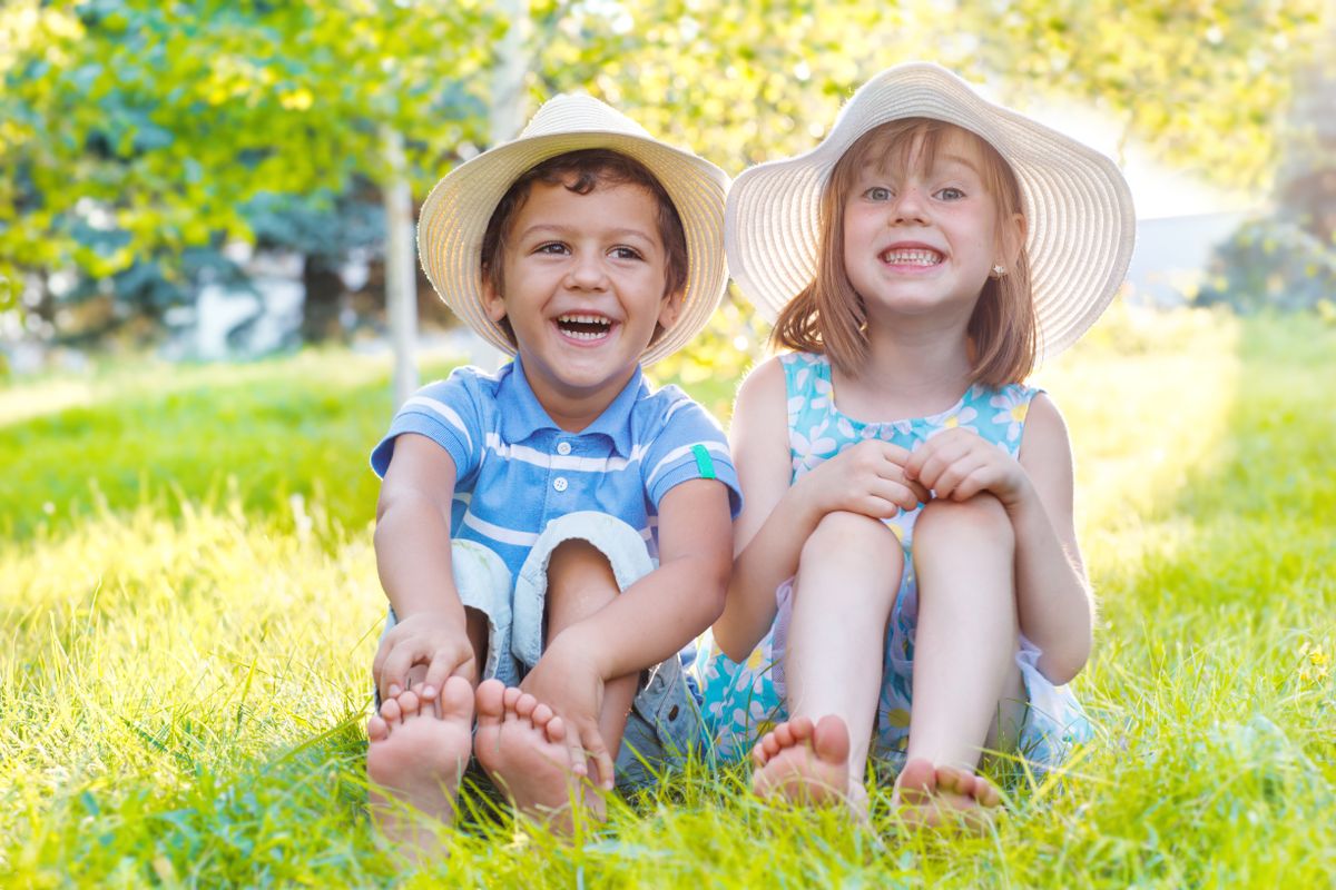 Two,Smiling,Kids,Sitting,On,Green,Grass,In,A,Park
Fontos, hogy védjük a fejünket a tűző naptól