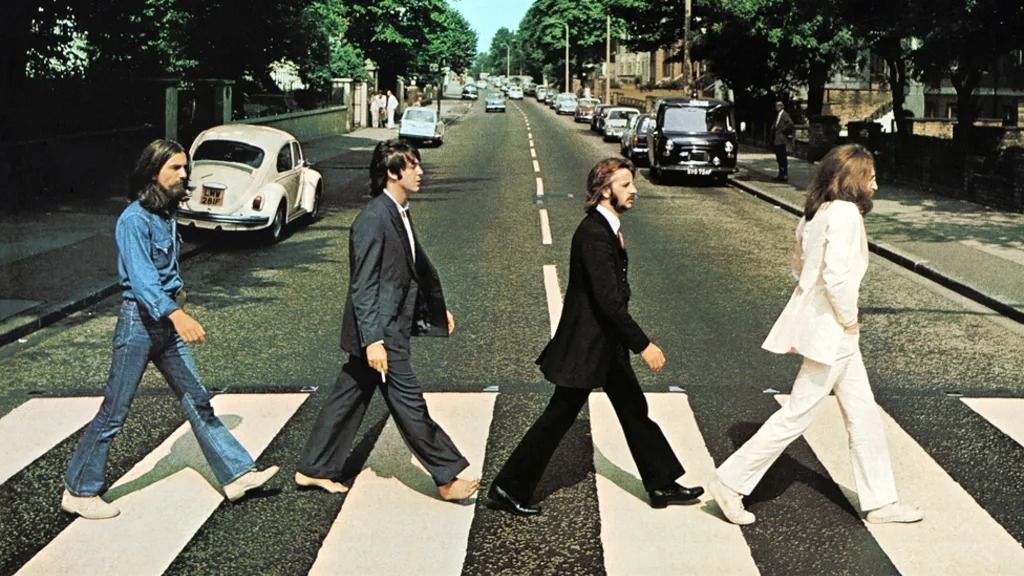 A "halott" Paul mögött a "sírásó" George, előtte a "gyászoló" Ringo, az élen a "pap" John